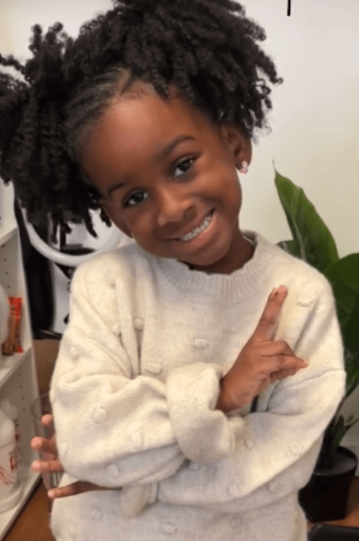 Smiling child wearing a cozy sweater.